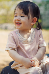 Baby girl wearing Avauma Pink Ivory floral layered summer tee outdoors