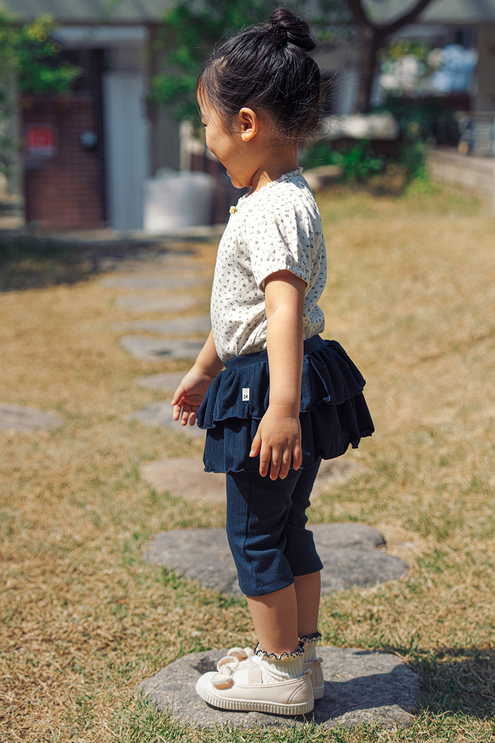 Side view of a toddler in Avauma deep navy skirted leggings, stylish tiered ruffle design for active 1-3 year olds.