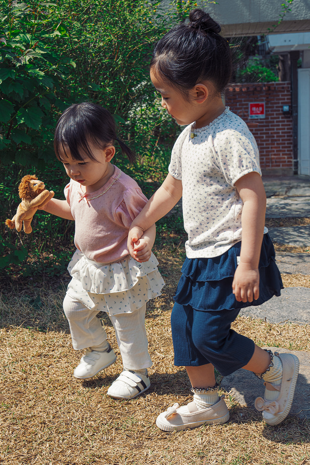 Two toddlers playing together wearing Avauma 2-in-1 skirt leggings, lightweight and breathable 100% cotton playwear.