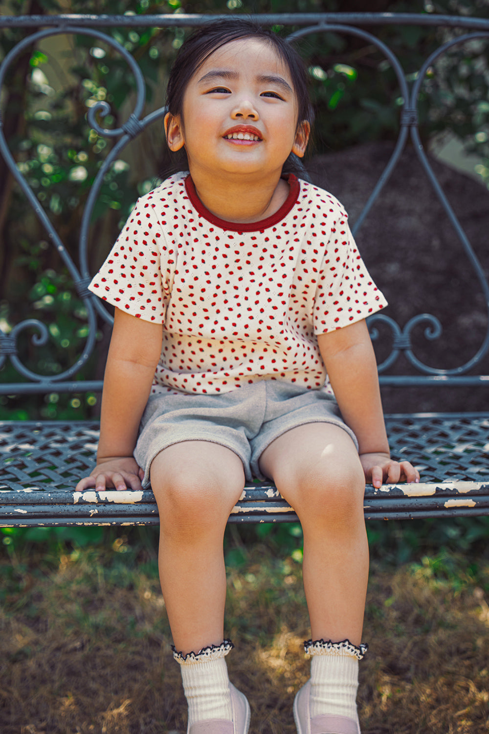 Cute toddler girl sitting in AVAUMA casual summer berry print baby outfit
