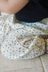 Detailed close-up texture of Avauma 100% cotton gauze muslin fabric with a blue floral pattern, high-quality material for children's clothing.