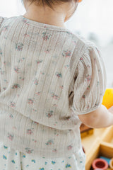 Back view of child wearing Avauma Buttercumin cardigan in sand floral.

