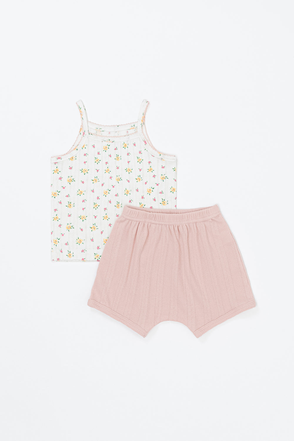 Flat lay of Avauma apricot daisy baby tank set – white floral sleeveless top with pink trim and apricot-pink shorts
