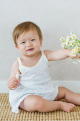 Smiling baby holding a flower in Avauma Butter Daisy tank top set
