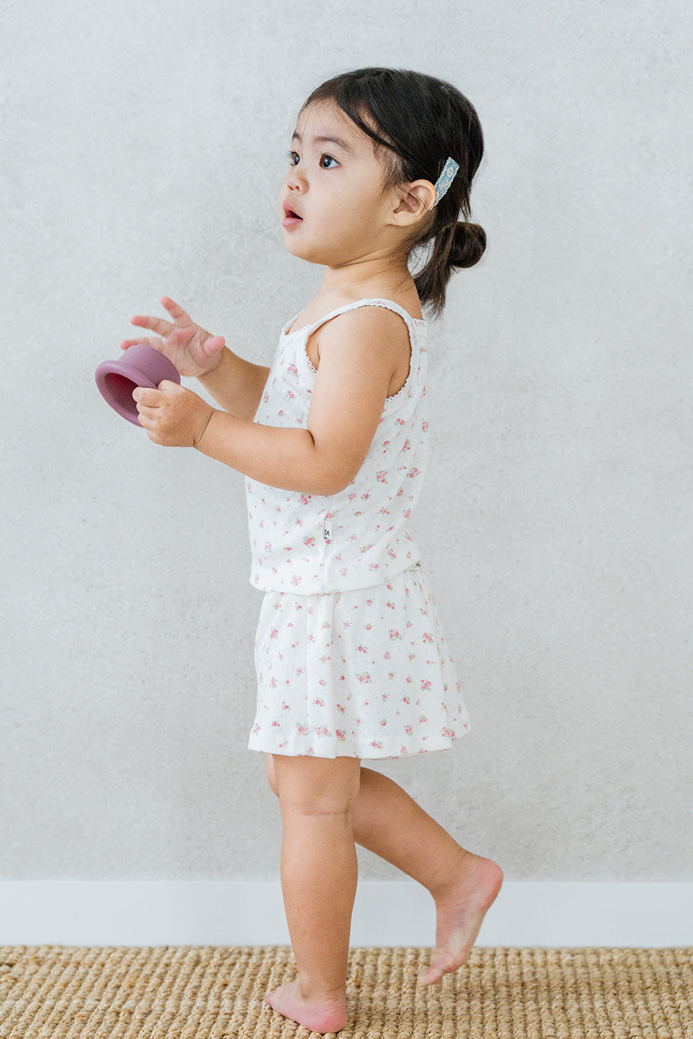 Baby girl walking in Avauma rose belle tank top set with soft floral print and frill shorts