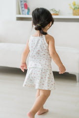 Back view of toddler wearing Avauma rose belle sleeveless picnic set, walking on white rug