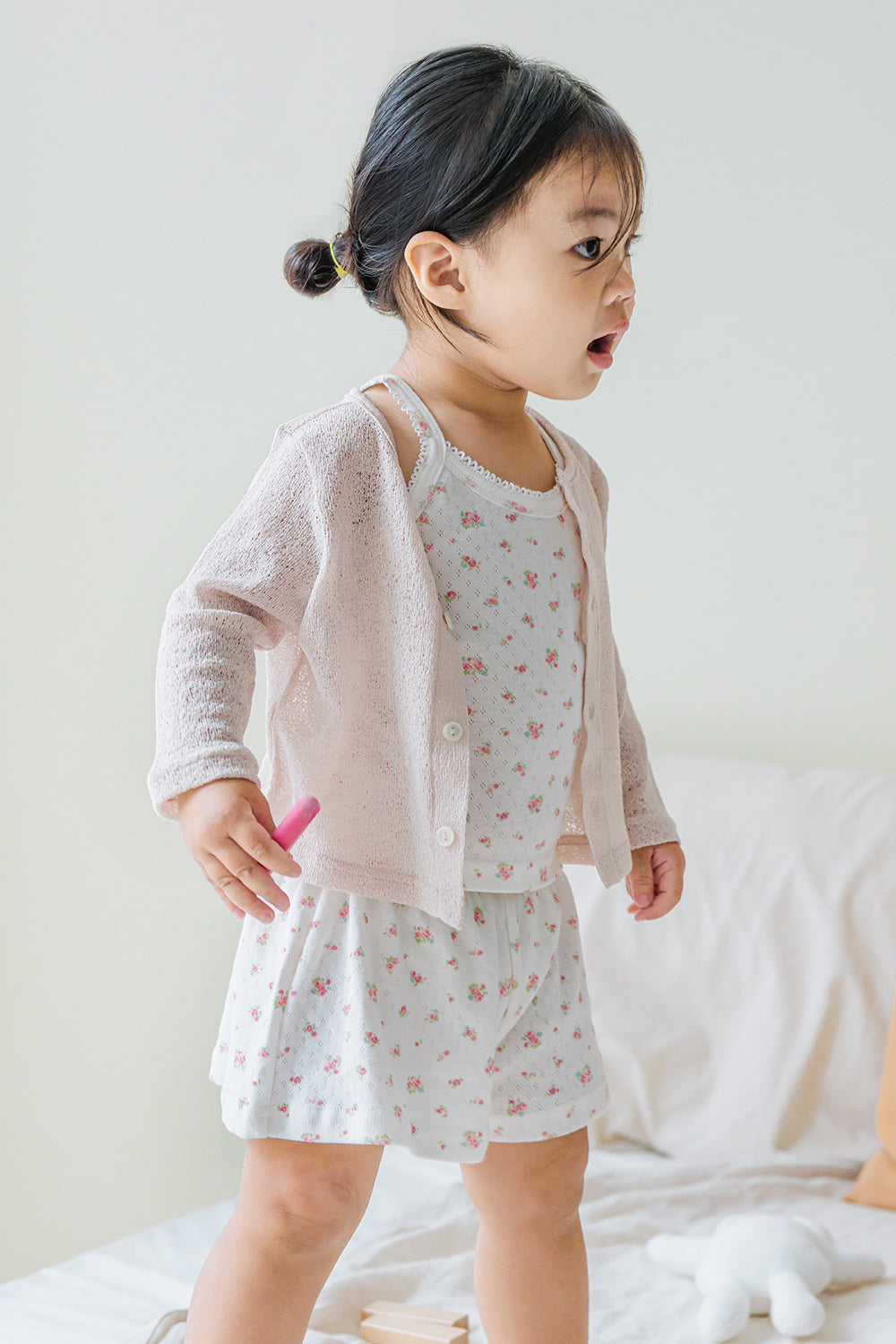 Toddler walking on bed in Avauma picnic tank top set rose belle with knit cardigan