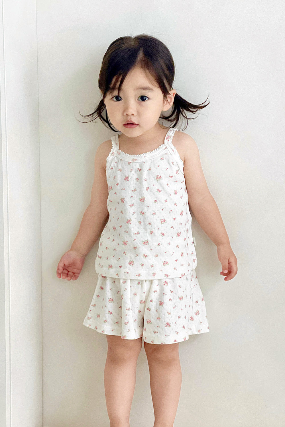 Toddler girl standing in Avauma picnic tank top set – rose belle floral sleeveless top and shorts


