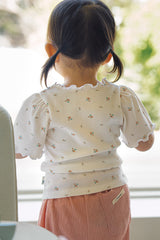 Back view detail of the Avauma toddler floral tee showing the ruffled collar and the pink pants with a back pocket label.