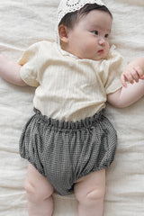 aby lying sideways in Avauma Berry Puff Bloomer, Camellia Check pattern