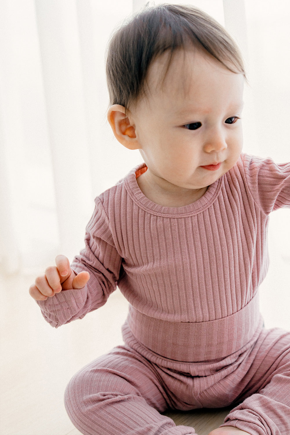 Baby girl wearing a soft cotton and modal pajamas set in Berry Berry Strawberry, comfortable sleepwear perfect for newborn and infant bedtime with a cute headband.