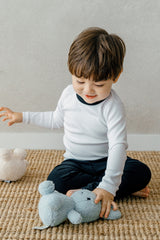 Toddler playing with a plush toy while wearing Avauma Coco Classic Long Sleeve Set in Black Moon color - cozy baby pajamas designed for comfort and ease of movement.