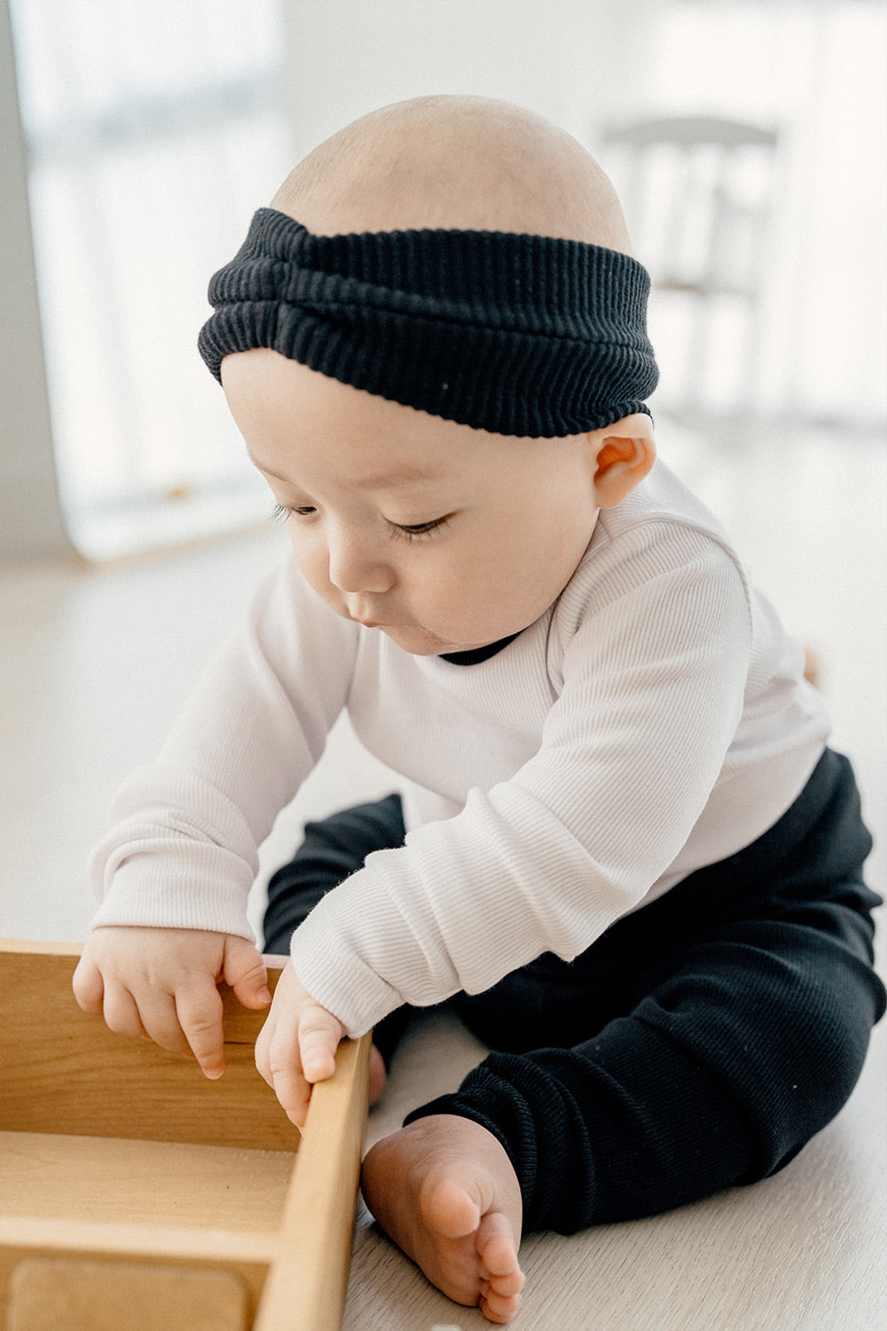 Close-up of a baby wearing Avauma Coco Classic Long Sleeve Set in Black Moon color - black and white loungewear set, perfect for baby pajamas or sleepwear.