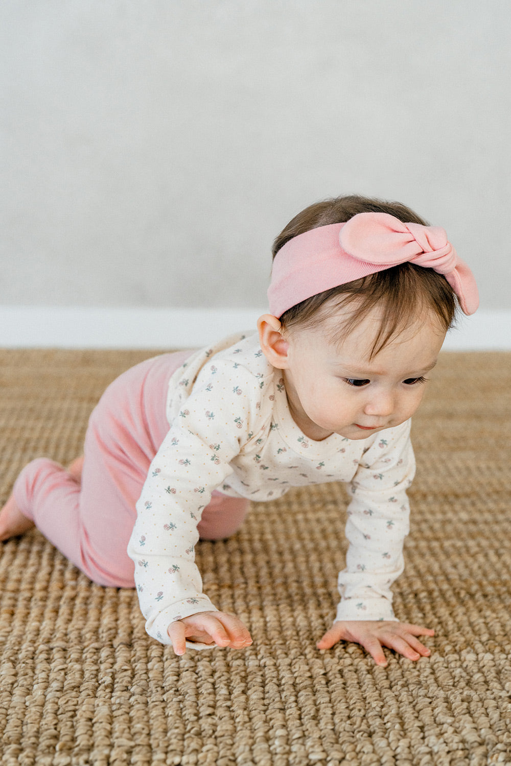 Toddler crawling in Avauma Lovely Duet Setup Blossom Strawberry, designed for comfort and flexibility with floral prints and pink pants.