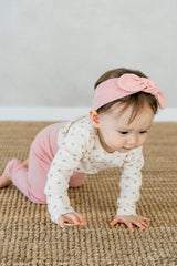 Toddler crawling in Avauma Lovely Duet Setup Blossom Strawberry, designed for comfort and flexibility with floral prints and pink pants.