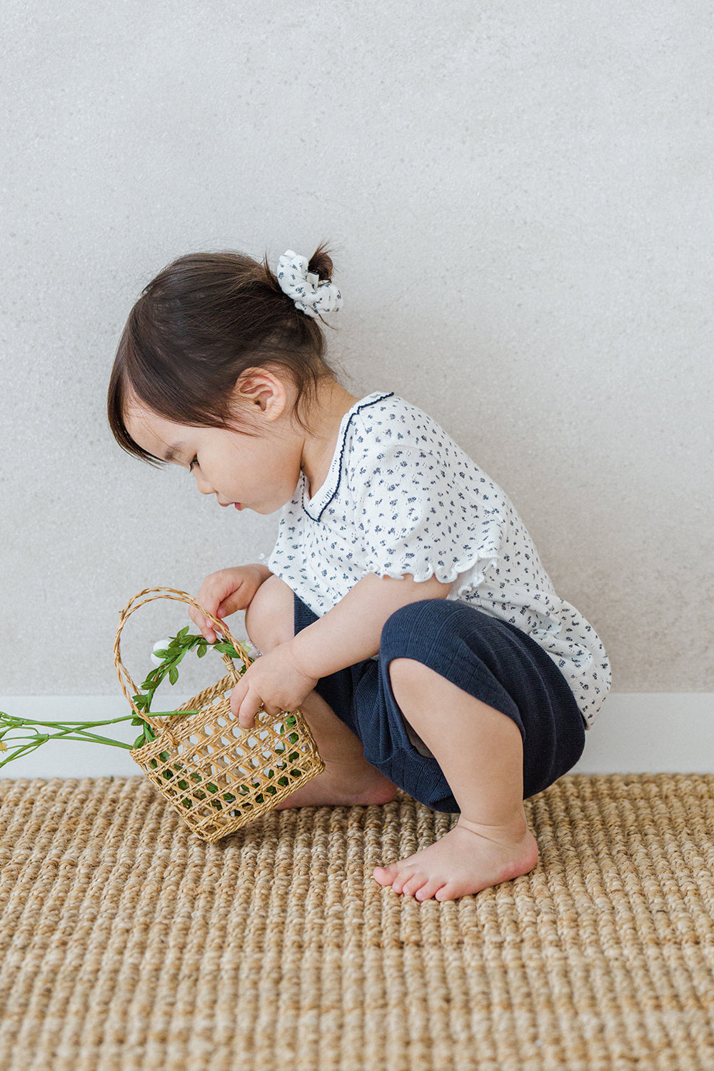 Avauma breeze garden baby setup indigo whisper - toddler picking flowers in white floral shirt and navy shorts

