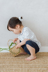 Avauma breeze garden baby setup indigo whisper - toddler picking flowers in white floral shirt and navy shorts

