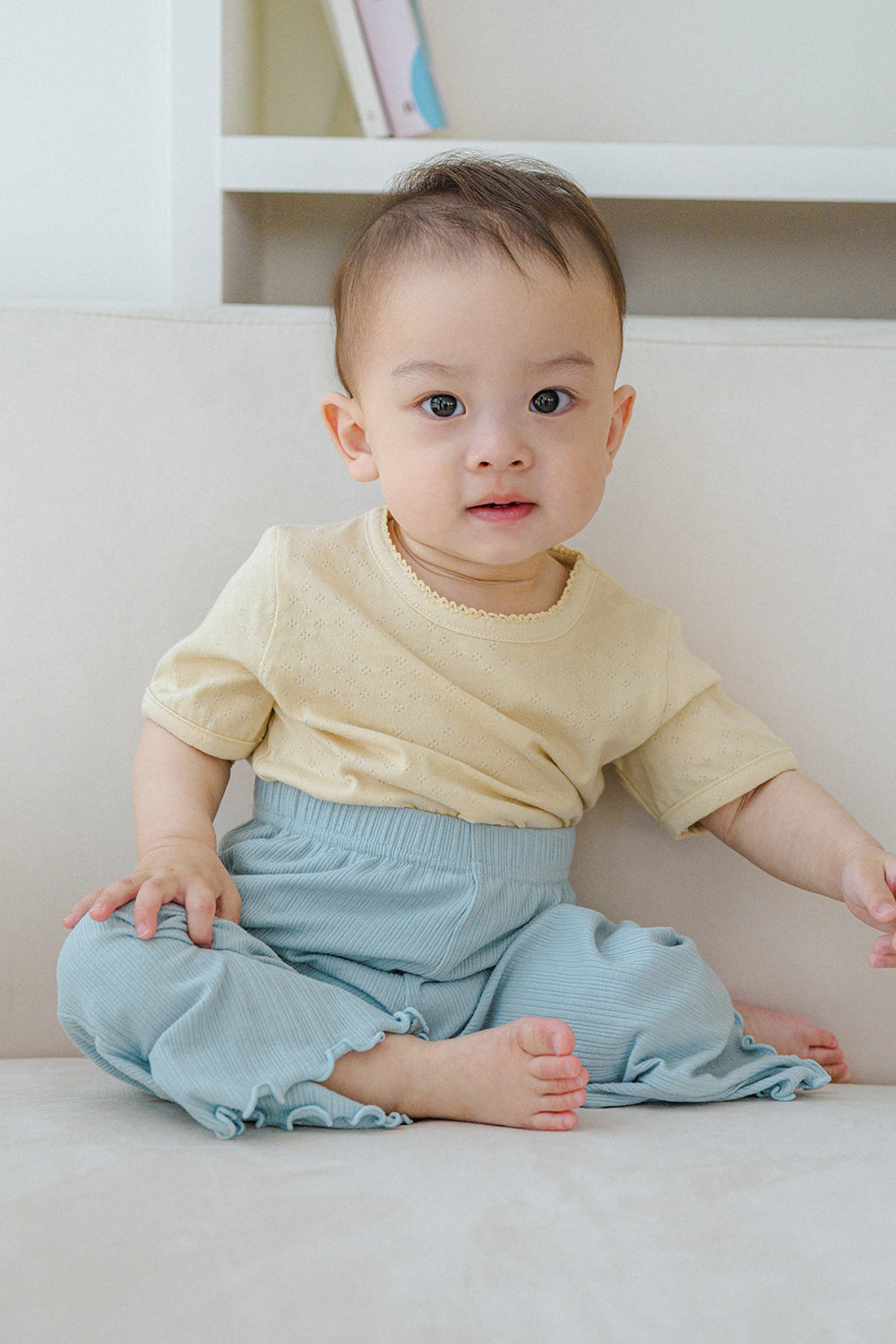 Baby wearing oat beige short sleeve t-shirt with lace trim, paired with light blue pants – Avauma

