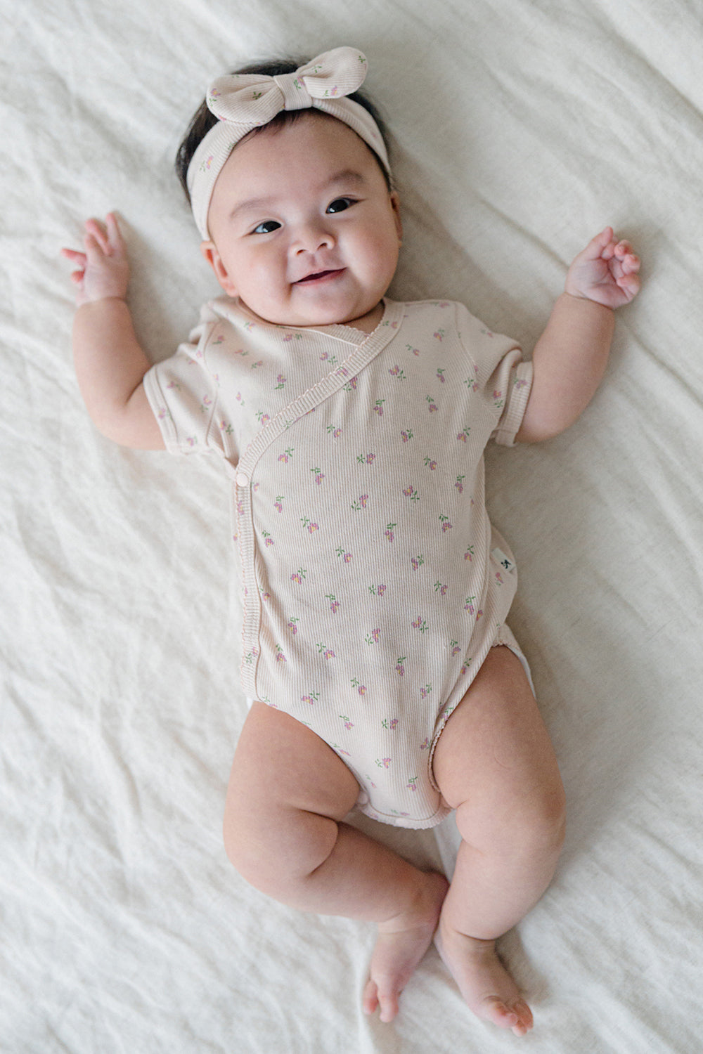 Baby Lying Down in Avauma Clare Peach Cream Short Sleeve Cotton Bodysuit, Perfect for Everyday Wear

