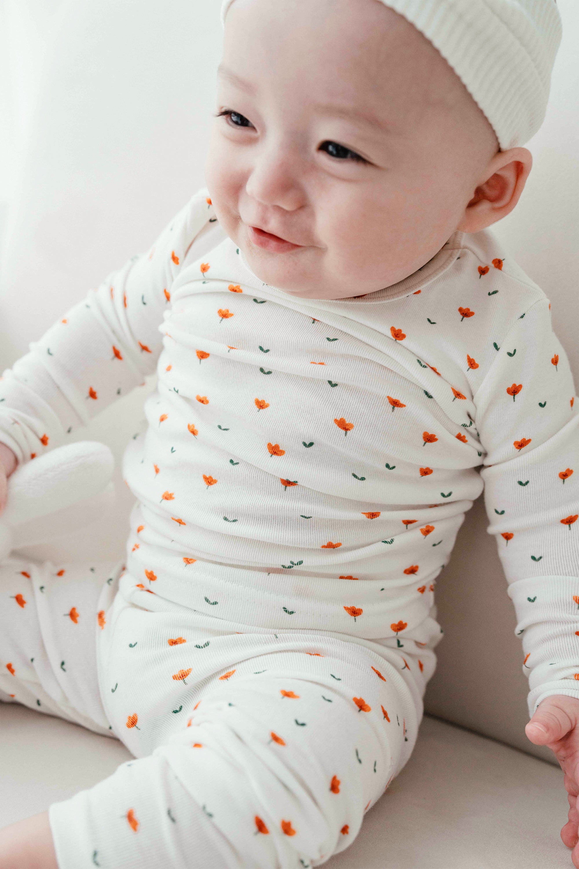 Back view of a baby in Avauma Mini Fleur Long Sleeve Set - Floral Africot, emphasizing the soft fabric and cheerful floral details of the pajama set.