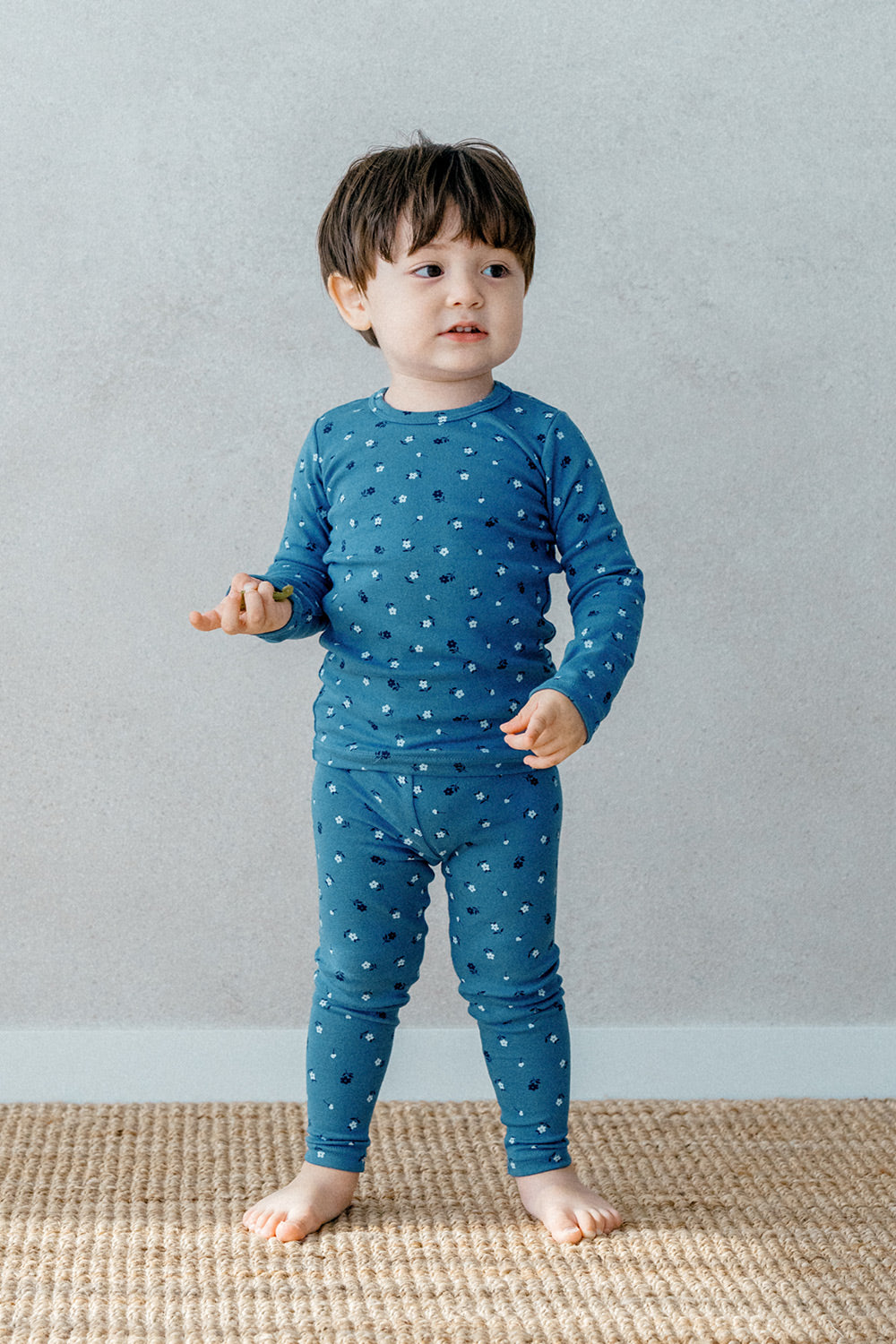 Toddler in Avauma Mini Fleur Long Sleeve Set - Floral Navy, a comfortable and stylish deep blue pajama set adorned with soft floral details.