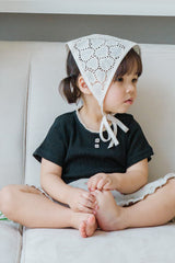 Toddler Sitting in Avauma Le Petite Classic Black Puff Sleeve T-Shirt, Stylish and Comfy Summer Top

