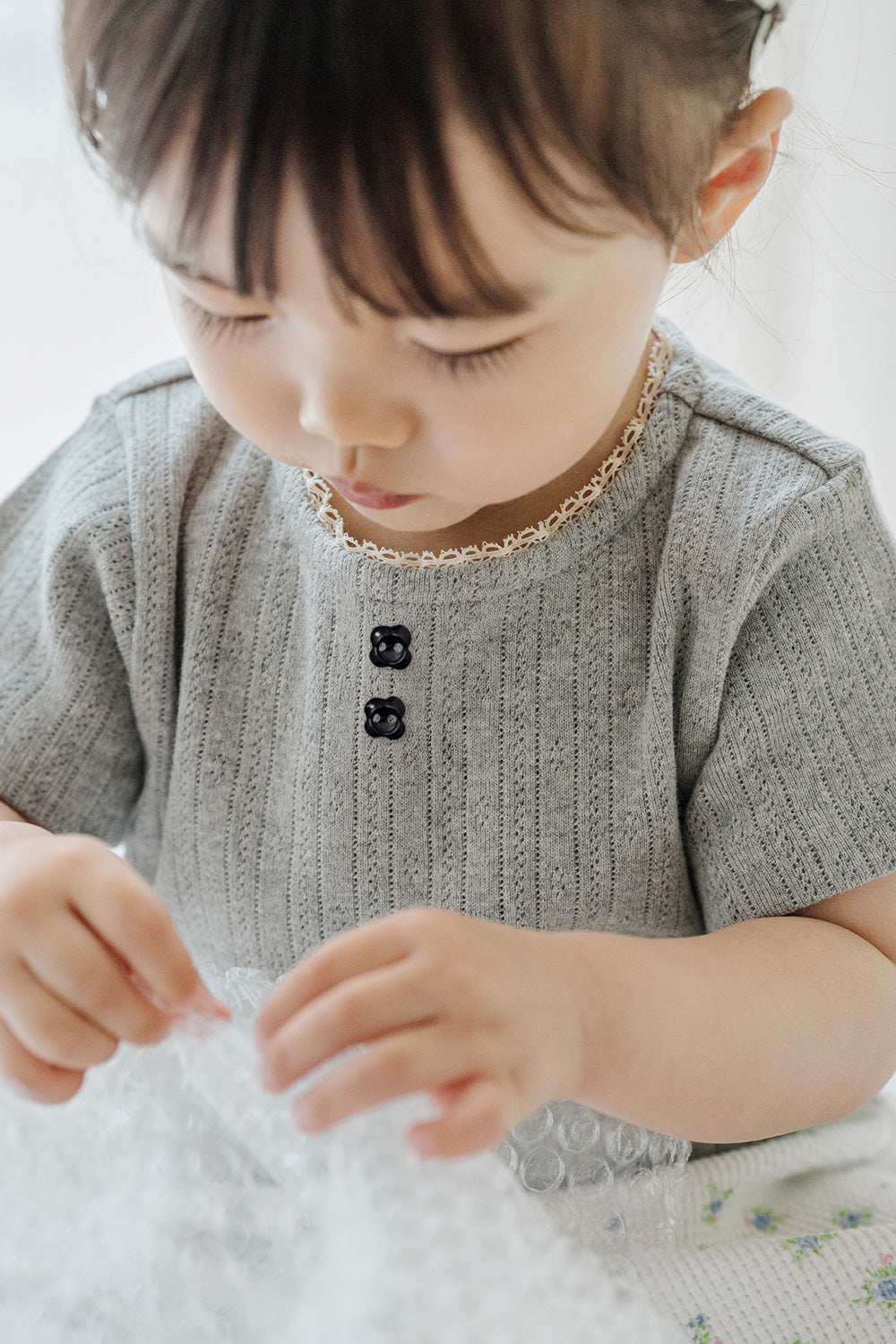 Close-up of Avauma Le Petite Soft Gray Short Sleeve Top with Buttons, Soft Knit Material for Summer

