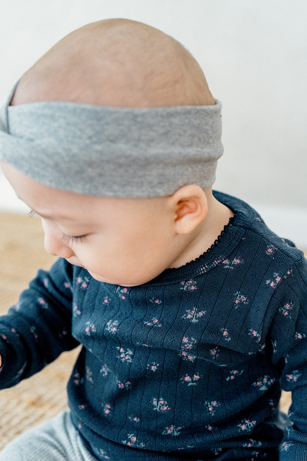 Toddler playing with toys while wearing Avauma Picot Flower Setup - Lunabel Gray, a cozy pajama set with a navy floral top and light gray ribbed pants.