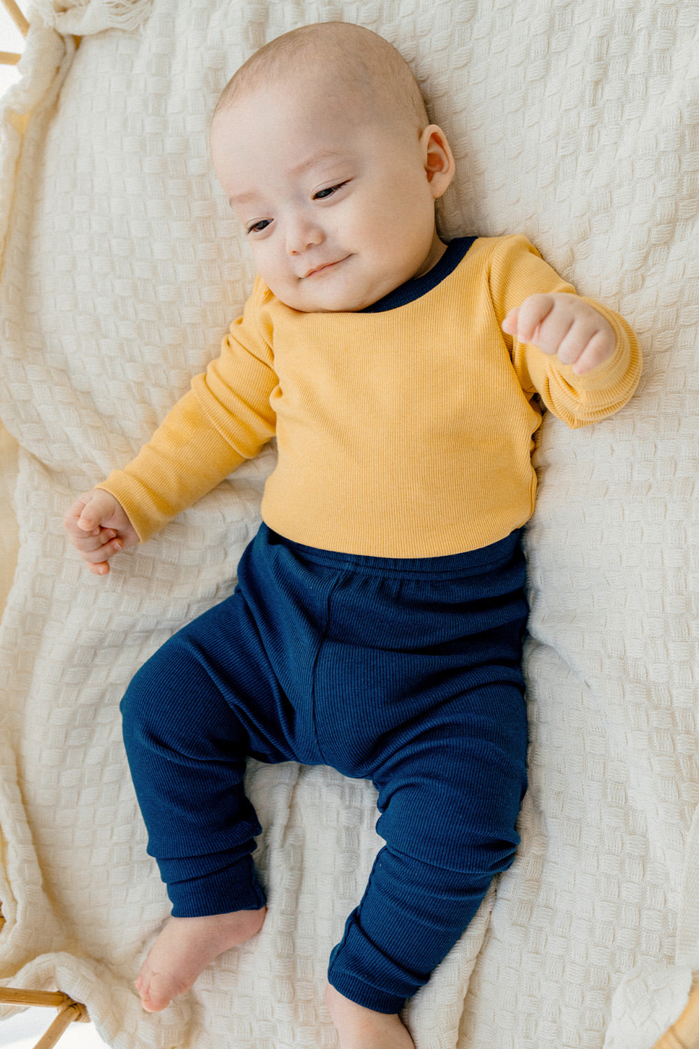 Baby lounging in Avauma's Coco Classic Long Sleeve Set in Mango Marine color - soft and breathable baby pajamas, perfect for nap time and play."