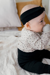 A baby in Avauma Lovely Duet Setup - Mini Heart Pale Black, showing a cozy and stylish sleepwear set with a cute heart print top and matching black pants.