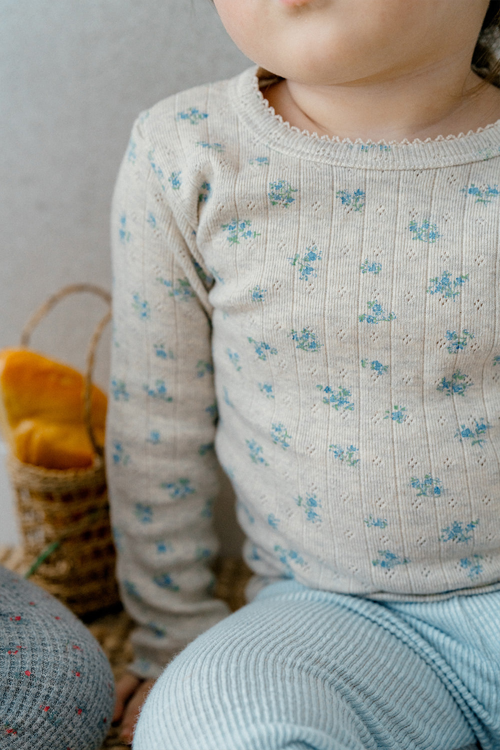 Close-up of baby wearing the Picot Flower Setup - Pebble Green by Avauma, showcasing a soft floral-patterned top with delicate blue flowers and ribbed fabric texture, perfect for a comfortable and charming baby outfit.