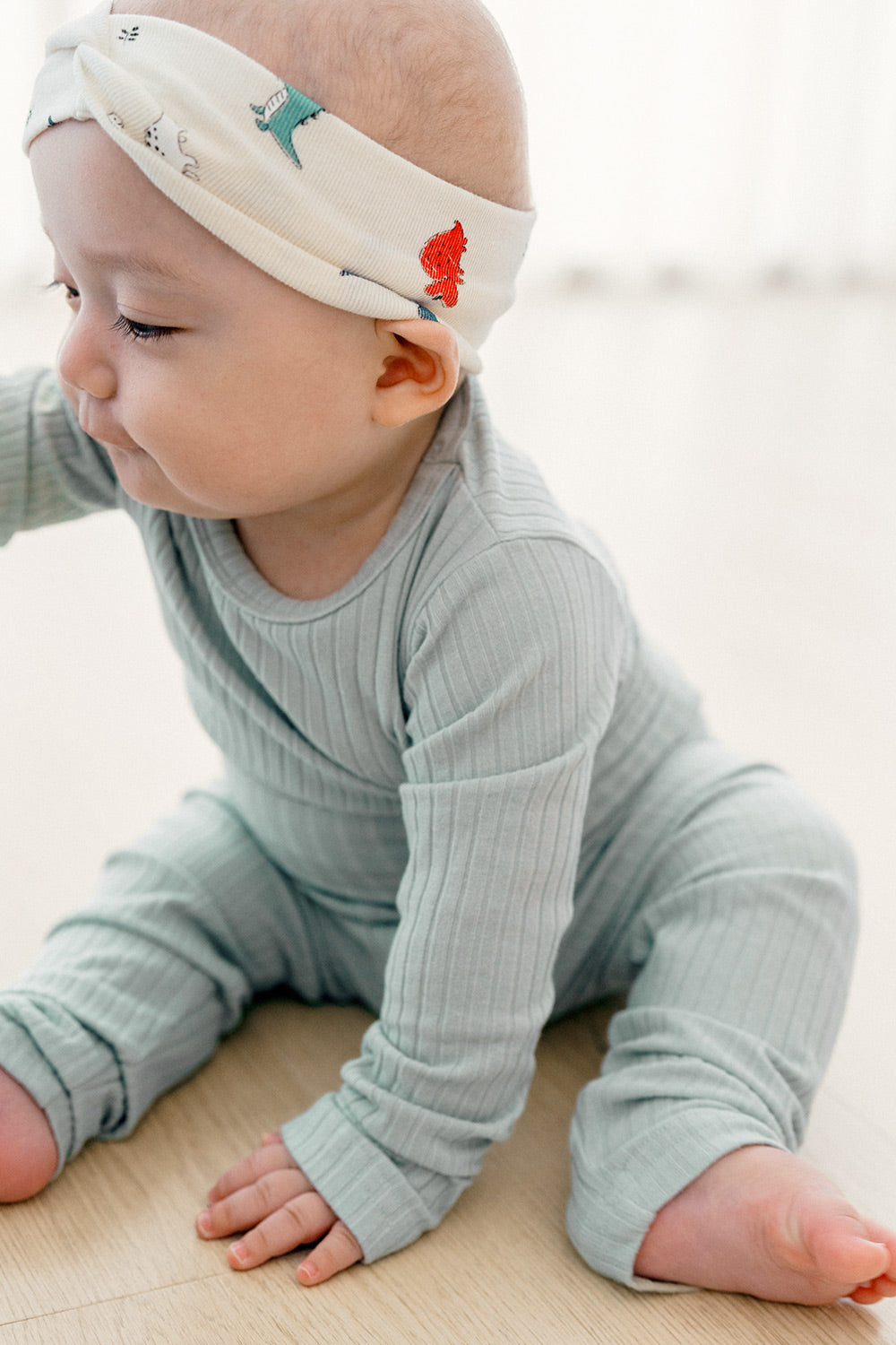 Baby in Avauma Pogny sleepwear pajamas set in Pistachio Sherbet color, playing on the floor in soft and flexible fabric for cozy sleep and relaxation