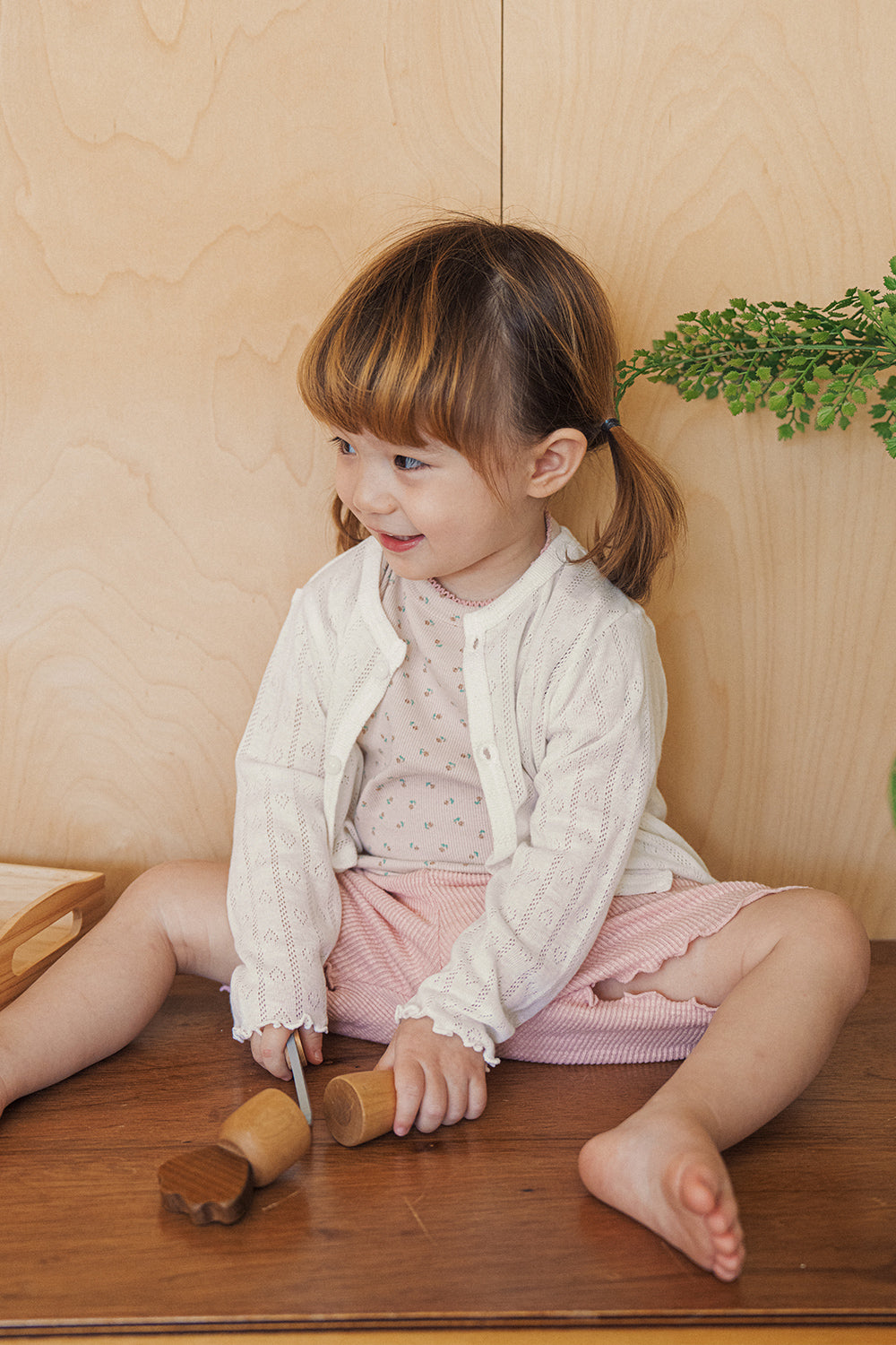 A girl wearing an Avauma rosy blush setup layered with a white lace cardigan for a cozy look.