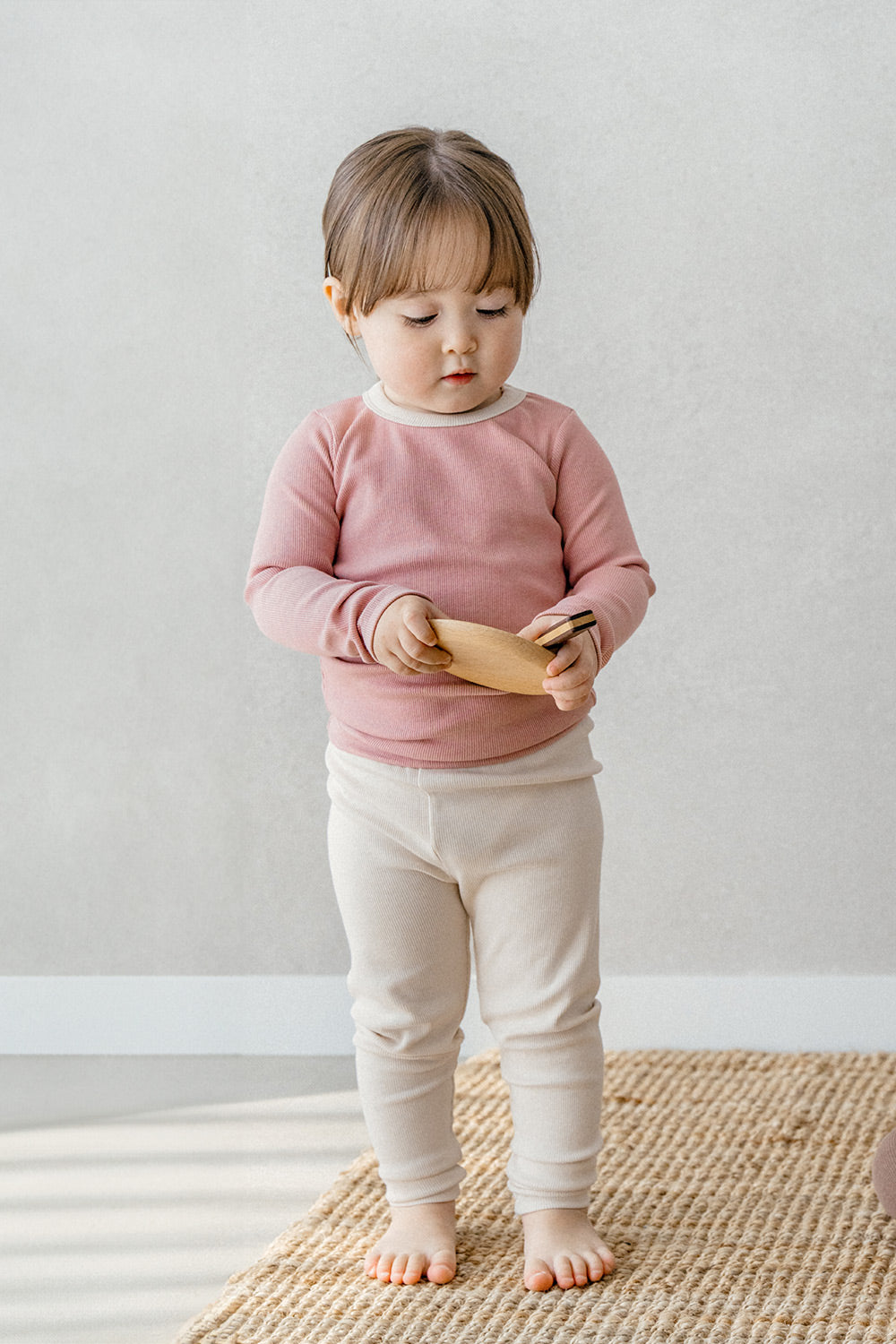 Toddler wearing Avauma's Coco Classic Long Sleeve Set in Strawberry Cheese color - pink and cream baby pajamas, perfect for cozy sleepwear and playtime.