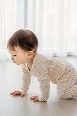 Baby crawling in Avauma Floral Melody Long Sleeve Baby Pajamas, showing the comfortable floral-patterned set in vanilla ivory.